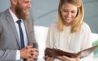 A woman is holding an open wallet while standing next to a man.