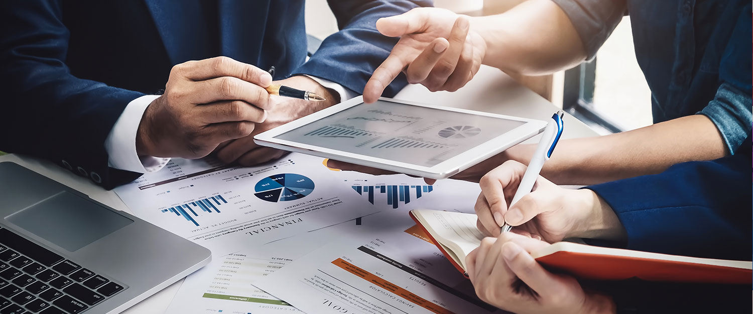 Advisors reviewing financial reports and a portfolio tablet together